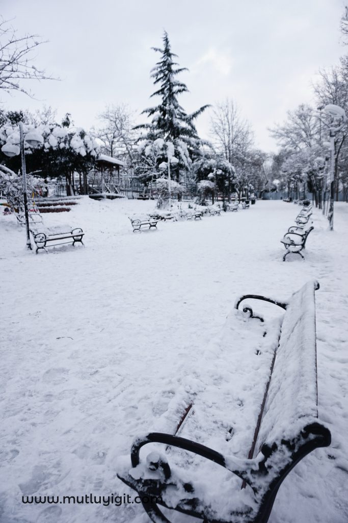 karla kaplı park bankı, kış temalı yalnızlık